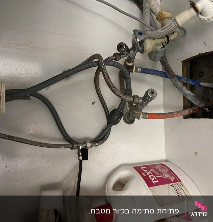 צינורות מים מתחת לכיור עם חיבורים וברזים